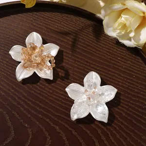 Detailed shot of pearlized white flower DIY charms featuring sparkling crystal bead centers.
