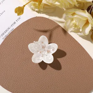 Close-up detail of white pearlescent crystal flower DIY patch, exquisite craft accessory.