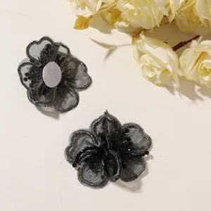 Primer plano detallado de flor bordada en organza negra con cuentas accesorio DIY.