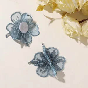Detalle de bordado de flores con cuentas de organza azul, accesorio DIY delicado para pelo.