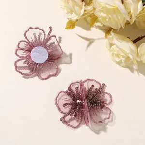 Detalle de parche de flor con cuentas de organza, exhibición artesanal de accesorios de pelo.