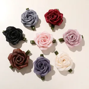 Detailed close-up view of colorful mesh rose flower DIY craft accessories and hair clips.