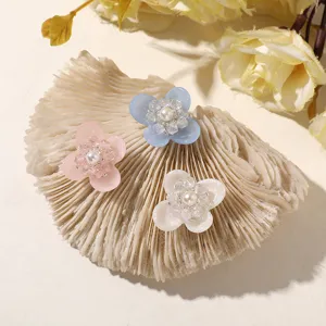 Close-up detail of resin four-petal flower DIY accessories with crystal and pearl center.