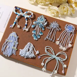 Close-up detail shot of handmade blue beaded bow and flower DIY accessories on wooden tray.