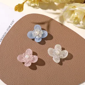 Close-up detail of resin four-petal flower DIY accessories with crystal pearl center.