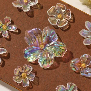 Detailed close-up of iridescent acrylic flower charms with gold stamens for DIY jewelry crafts.