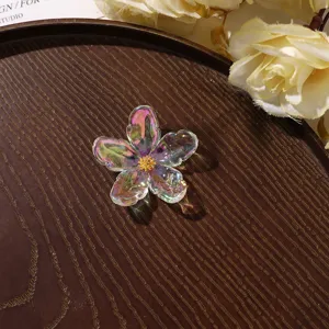 Detailed shot of iridescent acrylic flower charm with zircon center for DIY jewelry making.