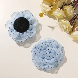 Primo piano di rosa in tulle a pois blu, accessorio per capelli DIY soffice e materiale per cucito.