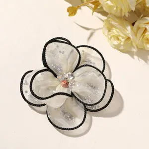 Mesh fabric flower DIY hair accessory with black edge and rhinestone center detail.