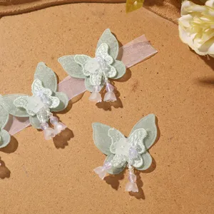 Closeup of fairy sweet green double-layer mesh butterfly patch with beaded tassel details.