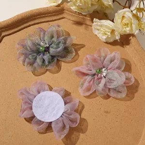 Detailopname van kleurverloop organza bloemapplicatie met strass hartje, ideaal voor DIY.