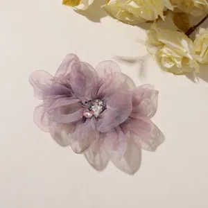 Gedetailleerd overzicht van organza bloem met sprankelende strasskern voor creatieve accessoires.