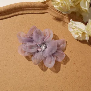 Prachtig detail van paarse organza bloem met sprankelende strass steentjes voor handwerk.