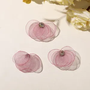 Close-up detail of pink mesh flower DIY accessories with crystal center for crafts.