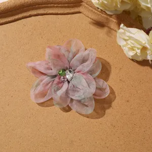 Close-up van gradiënt organza bloem accessoire met sprankelend strass steentje hart.