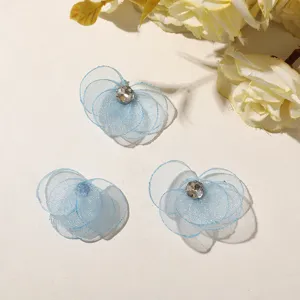 Close-up detail of blue mesh flower DIY accessories with sparkling rhinestone centers.