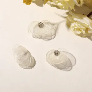 Detailed shot of sheer mesh flower DIY accessories with sparkling crystal center for crafts.