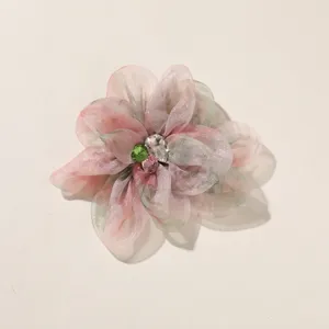 Gedetailleerd overzicht van handgemaakte stoffen bloem DIY accessoire met strass.