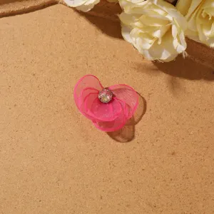 Close-up detail of pink sheer mesh flower DIY accessory with sparkling crystal center.
