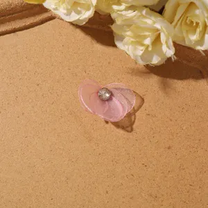 Organza flower DIY accessory detail shot, pink mesh floral component with rhinestone center.