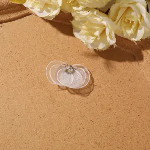Detailed closeup of white sheer mesh butterfly flower DIY hair accessory or earring component.
