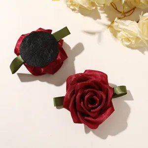 Closeup detail of dark red mesh rose flower with green ribbon leaves for DIY hair accessories.