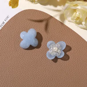 Detail shot of light blue resin four-petal flower DIY accessories with crystal and pearl centers.