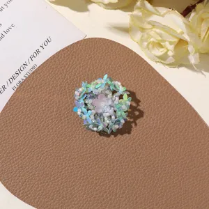 Close-up of handmade beaded flower with blue and pink translucent sequins for DIY jewelry.