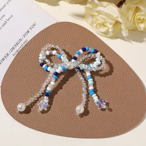 Close-up detail of handmade blue beaded bow accessory with pearls and star pendants for DIY crafts.