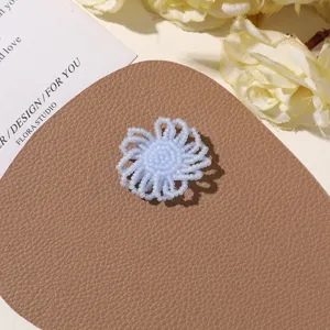 Detail shot of handmade light blue beaded flower DIY accessory, perfect for custom jewelry design.