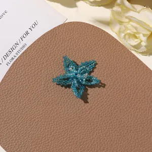 Close-up of summer sea salt blue handmade beaded flower DIY accessory for earrings and hairpins.