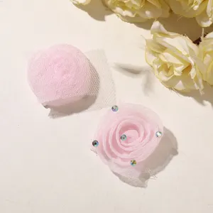 Vue rapprochée d'accessoires de fleurs de roses 3D en mousseline douce avec des strass.