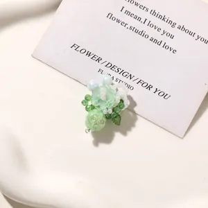 Green beaded flower DIY accessory close-up, delicate floral charm for earrings and shoes.