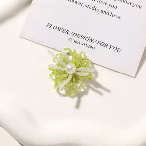Green beaded flower DIY accessory detail shot, handmade pearl center for shoes earrings craft.