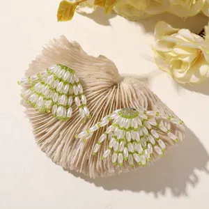 Detailed shot of fresh green beaded flower earrings or hair accessories with a natural style.