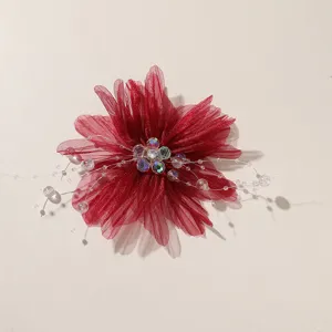 Close up view of exquisite red mesh fabric flower detail featuring crystal beaded stamen center.