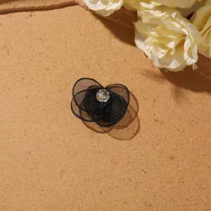 Detailed view of the black mesh flower DIY accessory with clear crystal center bead.