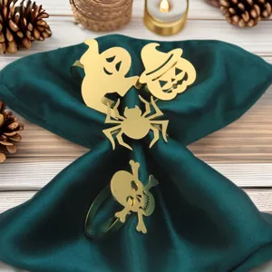 Halloween metal napkin ring set detail view, gold ghost pumpkin spider skull table decor.