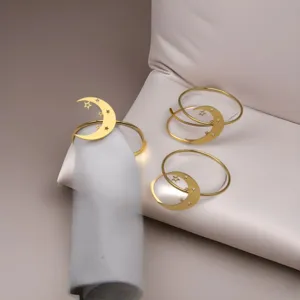 Gold metal napkin rings with hollow moon and star design, elegant table decor for dining.
