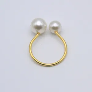 Elegant gold double pearl napkin ring for wedding table decor, hotel banquet table setting detail.