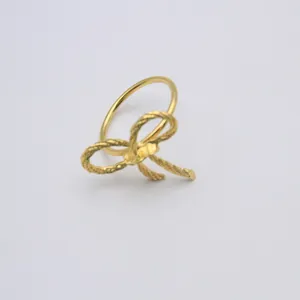 Detail shot of a golden twist rope bow napkin ring, elegant table decor accessory for wedding.
