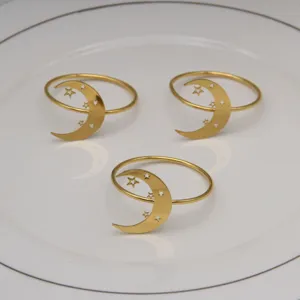 Detail view of gold metal moon and star napkin rings set, elegant table decor for party.