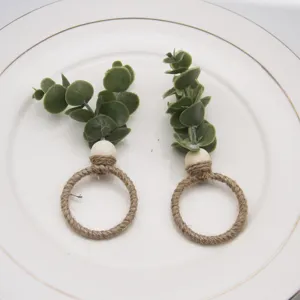 Handmade jute rope napkin rings with wooden beads and faux eucalyptus leaves for rustic table decor