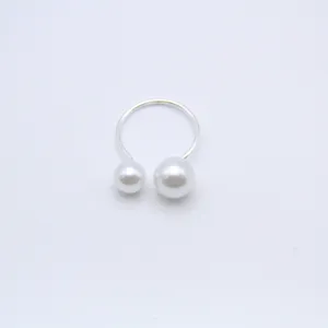 Detail view of an elegant open adjustable ring featuring double pearls in different sizes.