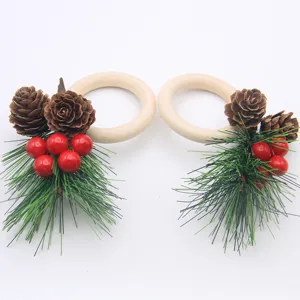 Wooden Christmas napkin ring detail showing pine cones, red berries and green pine needles.