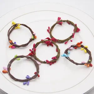 Handmade woven vine napkin rings with colorful berry decor, perfect for party and table setting.