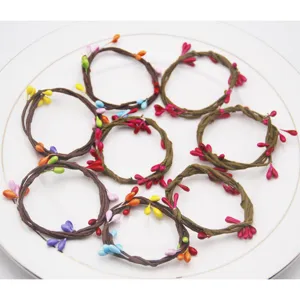 Handmade woven napkin rings with colorful berries for party and restaurant table decor detail