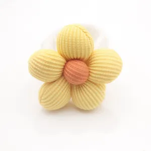 Détail en gros plan d'un rond de serviette en tissu fait main avec fleur rembourrée et texture.