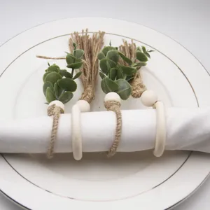 Handmade woven jute napkin ring featuring wooden beads and eucalyptus leaf decoration