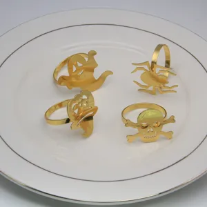 Set of 4 gold Halloween napkin rings featuring ghost, spider, and skull designs for table decor.